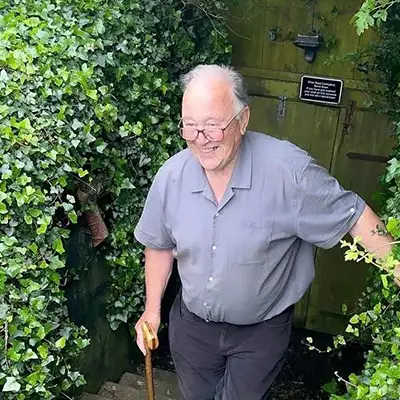 a smiling elderley man climbing steps